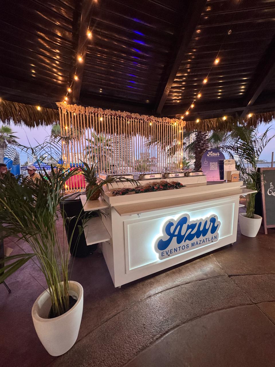 Terraza junto al mar al atardecer, montada con mesas para un evento en Mazatlán