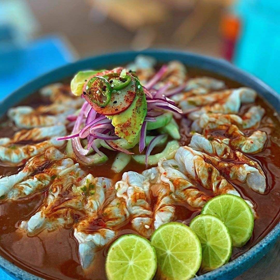 Plato de pescado fresco con salsa cítrica tipo ceviche servido en una mesa elegante